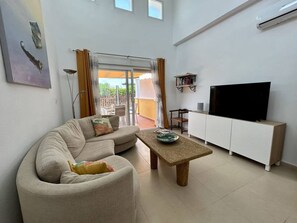 A living room with a sofa, a coffee table, a TV, and a cabinet.