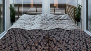 Una habitación con una cama, ventanas amplias y vistas a un paisaje nevado.