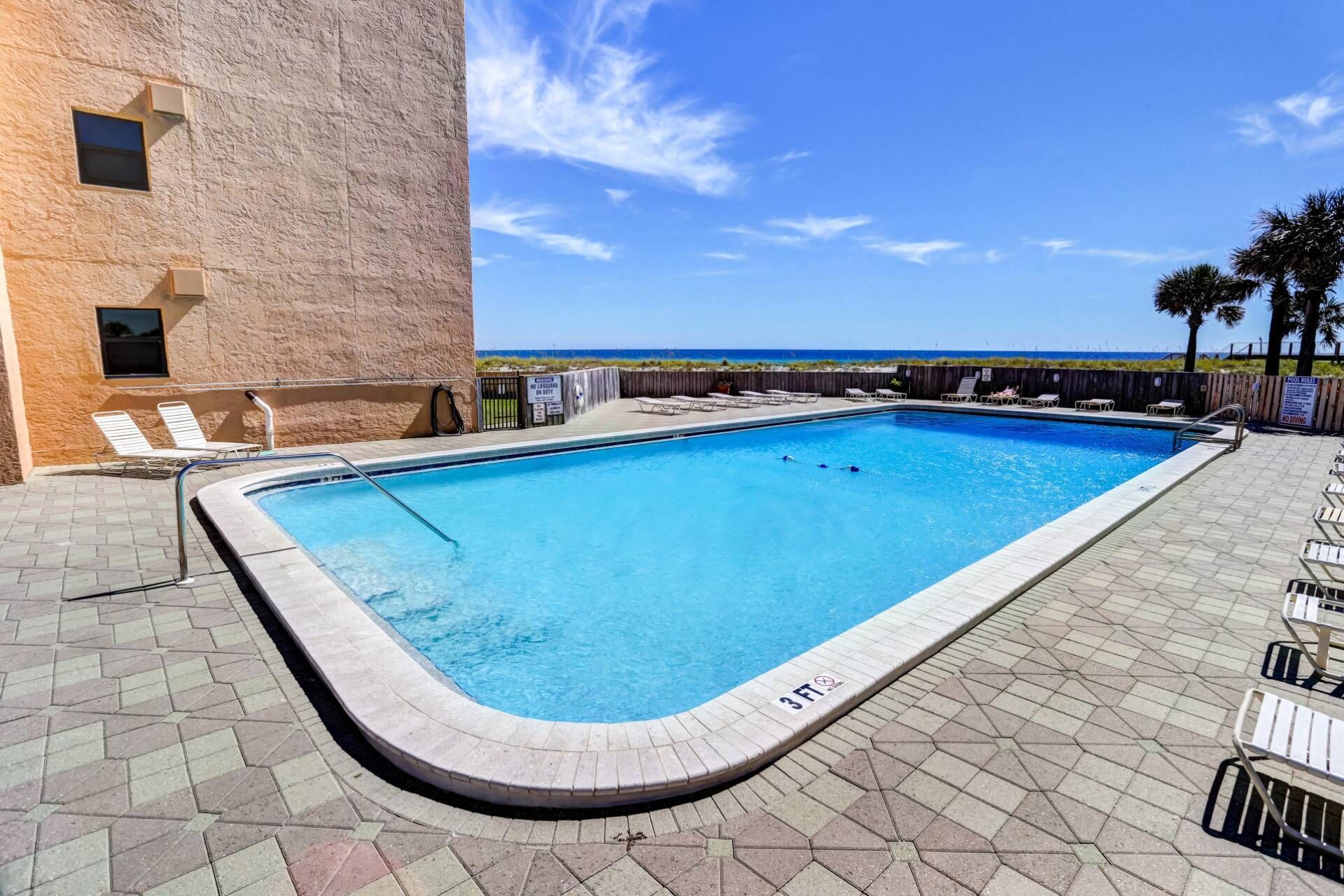 Condo pool with seating and lounge chairs