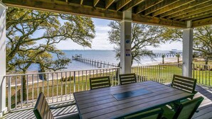 A covered outdoor seating area with a view of the water and dock.