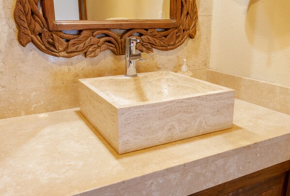 A bathroom with a marble sink, a wooden-framed mirror, and a soap dispenser. - Luxurious retreat with Private Pool & Modern Mexican Charm! 2BD Condo for rent i (Puerto Vallarta)
