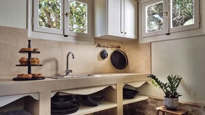 Uma cozinha com um suporte de servir em três níveis, uma pia e um esguicho para pendurar panelas.