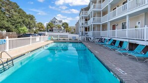 A swimming pool with a white fence, lounge chairs, and a building with balconies. - *Fall into Savings-20% Off New Bookings thru 2026* (Surfside Beach)