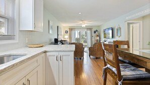 A spacious kitchen with white cabinets, a dining area with wicker chairs, and a view to the outside. - *Fall into Savings-20% Off New Bookings thru 2026* (Surfside Beach)