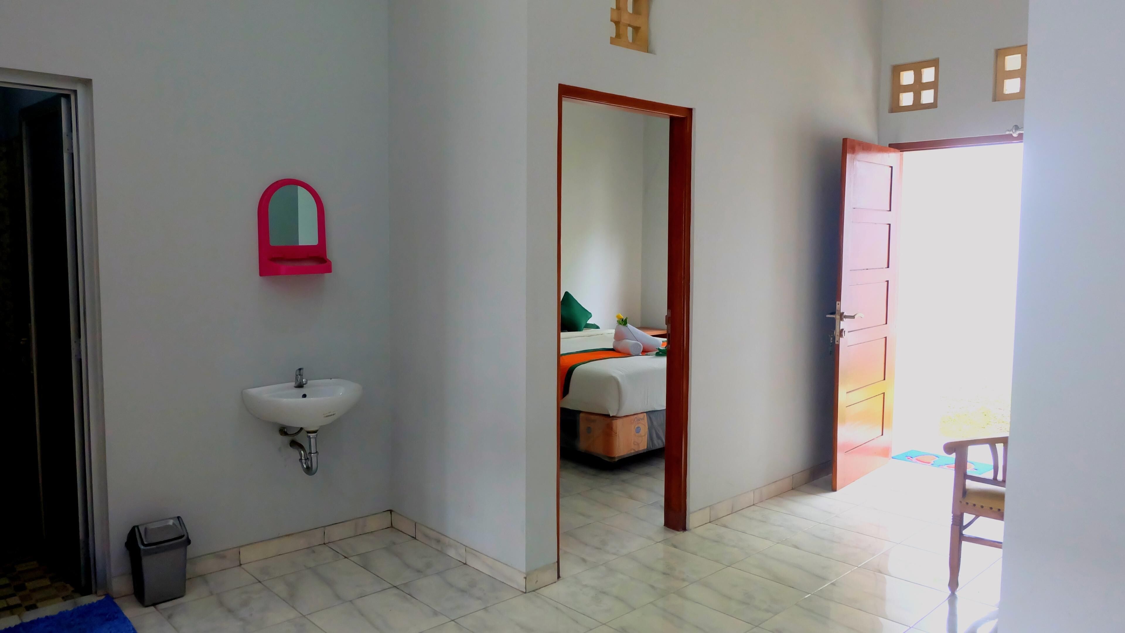 Quarto de hotel com banheiro, cama e vista para o exterior.