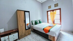 Um quarto com cama, guarda-roupa, mesa de cabeceira e janela com cortinas.