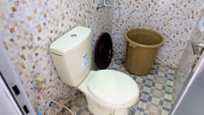 Um banheiro pequeno com vaso sanitário, bidê e lixeira.