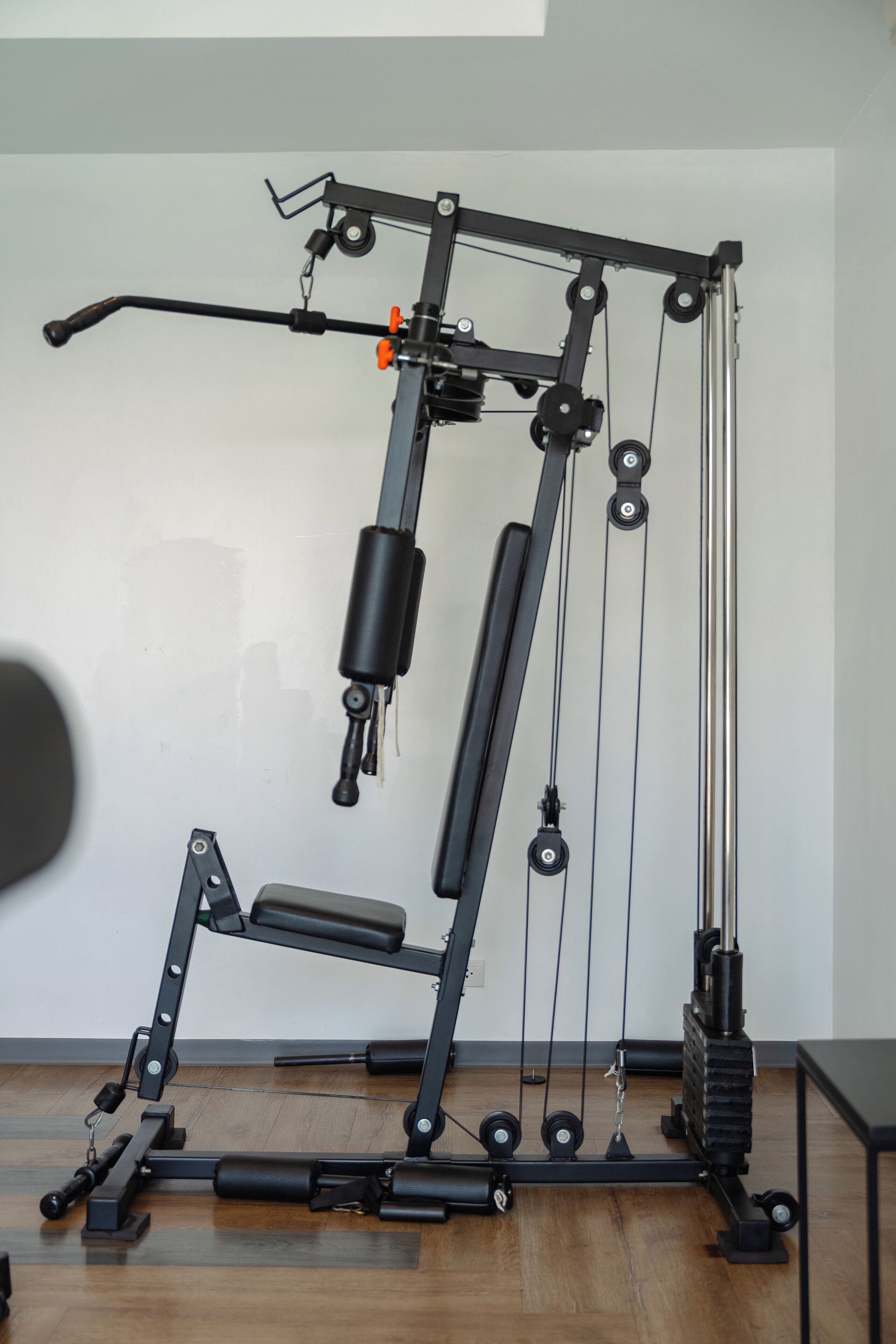 A gym with a pull-up bar, weight stack, and various exercise equipment.