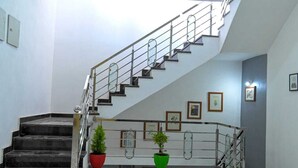 A staircase with metal railings and potted plants at the base. - Hotel Apni Haveli Villa (Udaipur)
