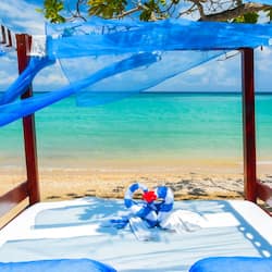 Relax in a cabana with a shaded lounge area overlooking the turquoise ocean.