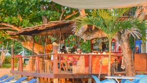 Un espace extérieur aménagé avec des meubles en bois, des chaises bleues et un bar.