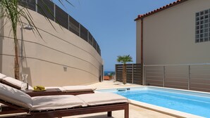 Ein Poolbereich mit Liegestühlen und einem Schwimmbecken.