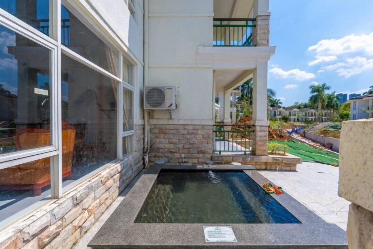 A swimming pool adjacent to a building with large windows and a stone facade.