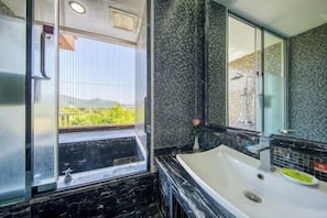Un baño con una ventana grande, una bañera y un lavabo.