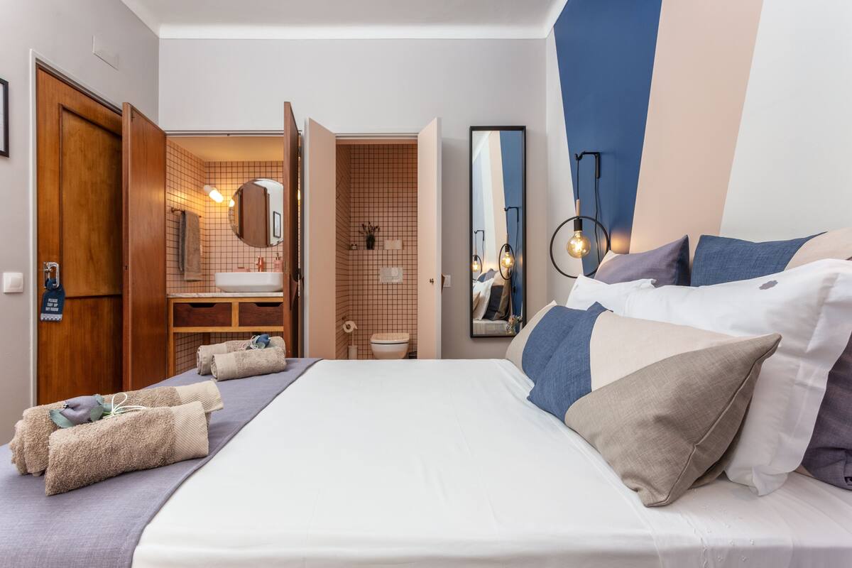 Hotellihuone, jossa on sänky, kylpyhuone ja suuri peili.