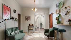 A living room with a green sofa, a round rug, and a ceiling light. - Downtown Alegria (Tavira)