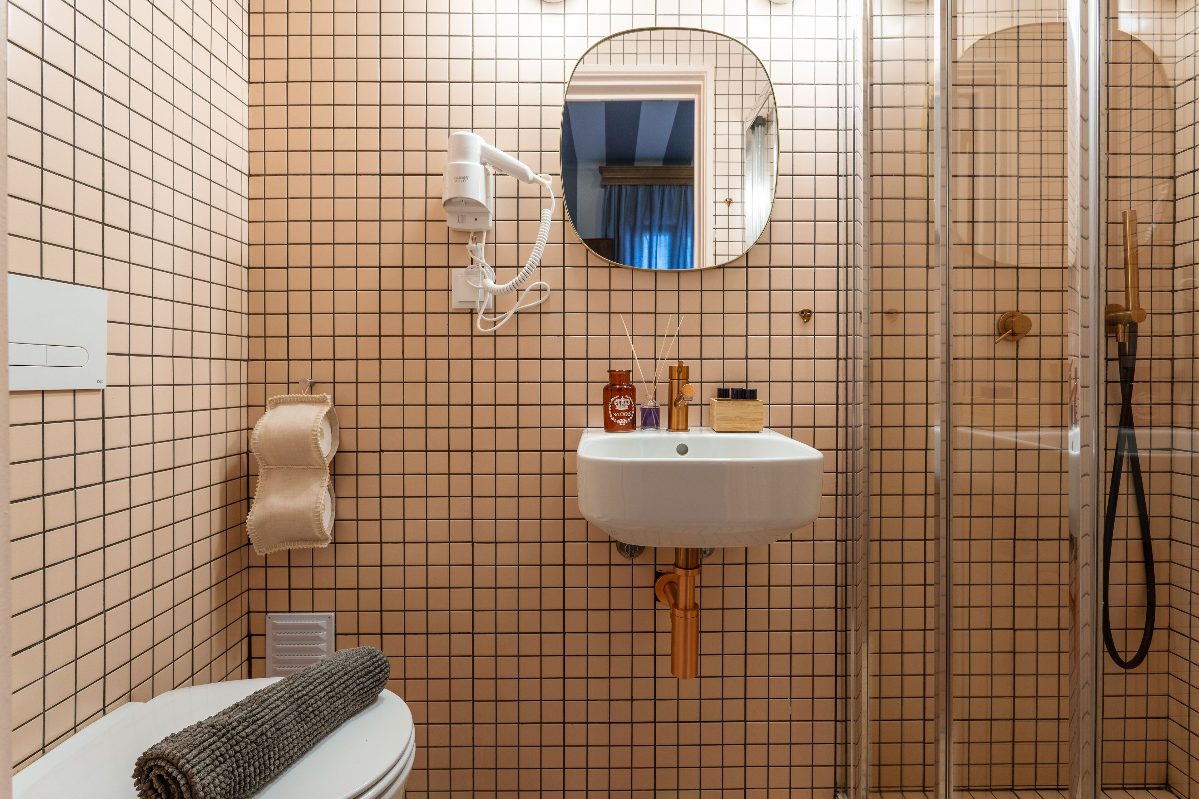Ein Badezimmer mit Toilette, Waschbecken, Spiegel und Dusche.