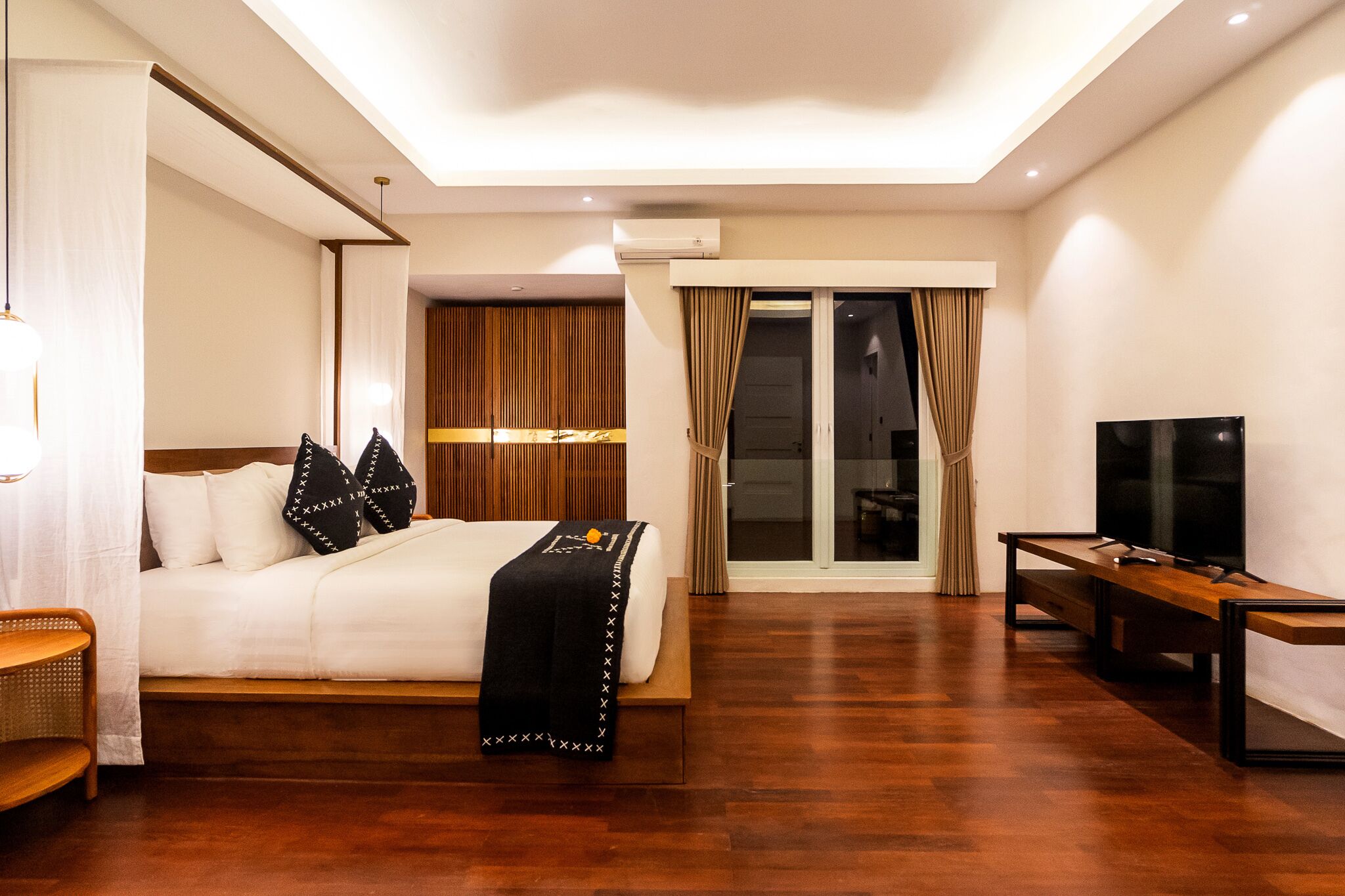 Une chambre d’hôtel moderne avec un grand lit, une télévision et un plancher en bois.