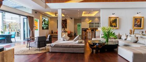 Un salón amplio con techo alto, muebles modernos y obras de arte en las paredes.