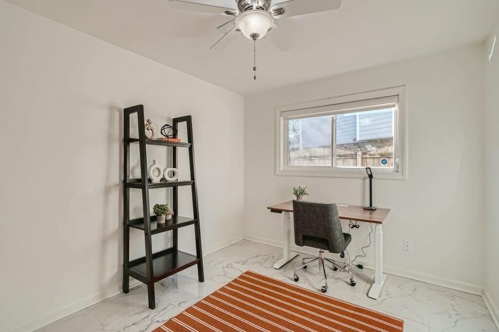 A room with a desk, chair, and a bookshelf.