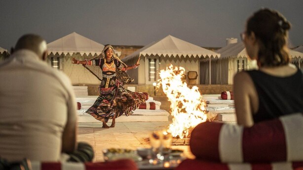 A person performing a dance with a fire in the foreground. - Desert Over Night Camp & Resort (Jaisalmer)