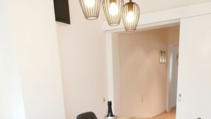 A modern dining area with a wooden table, six upholstered chairs, and a champagne bottle on the table.