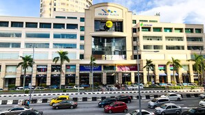 Un immeuble à plusieurs étages doté d’une façade incurvée, sur lequel on peut voir une enseigne bien visible indiquant « Island Plaza » et « Cold Storage ».