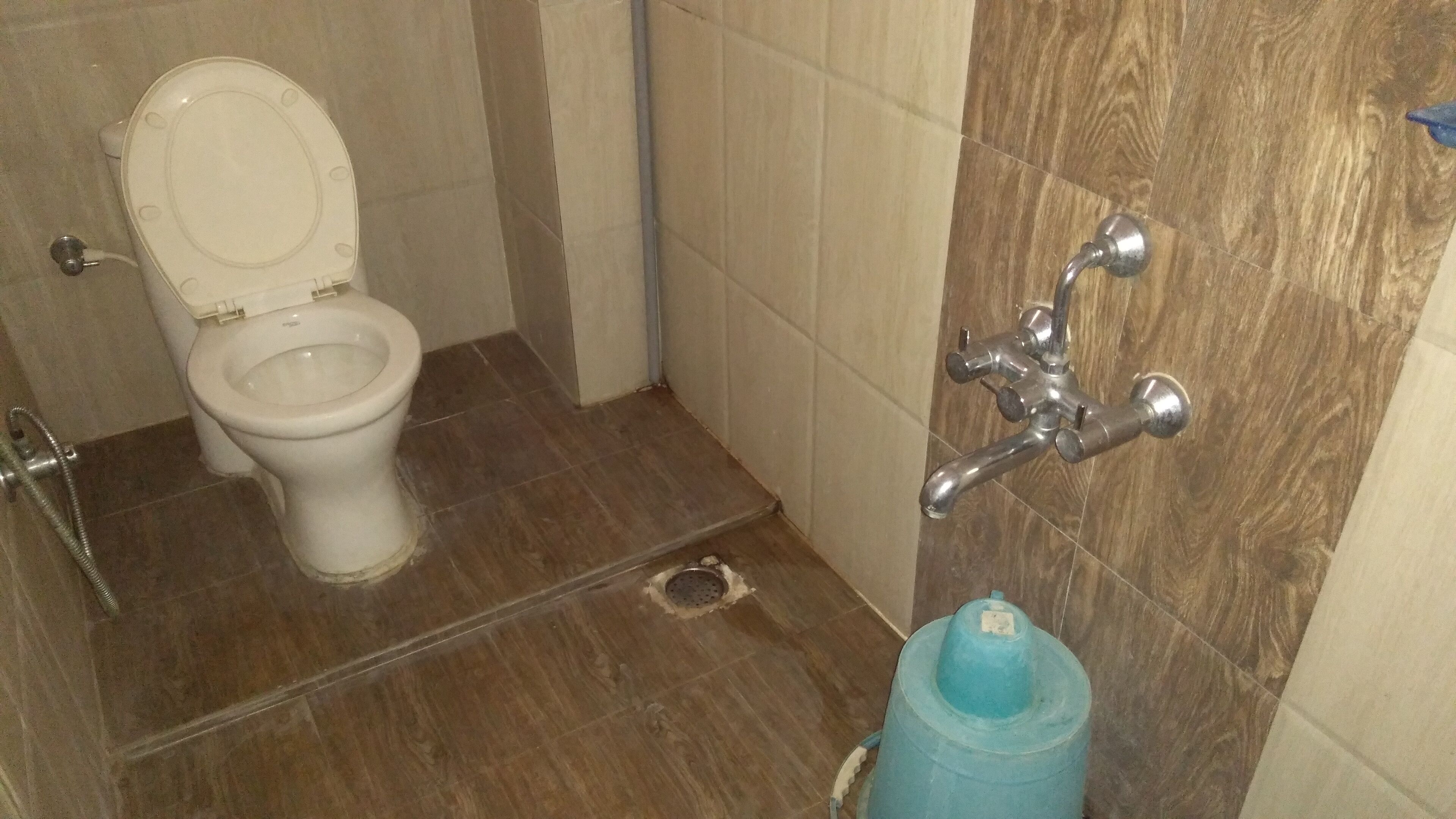 Um banheiro com vaso sanitário, chuveiro e pia.