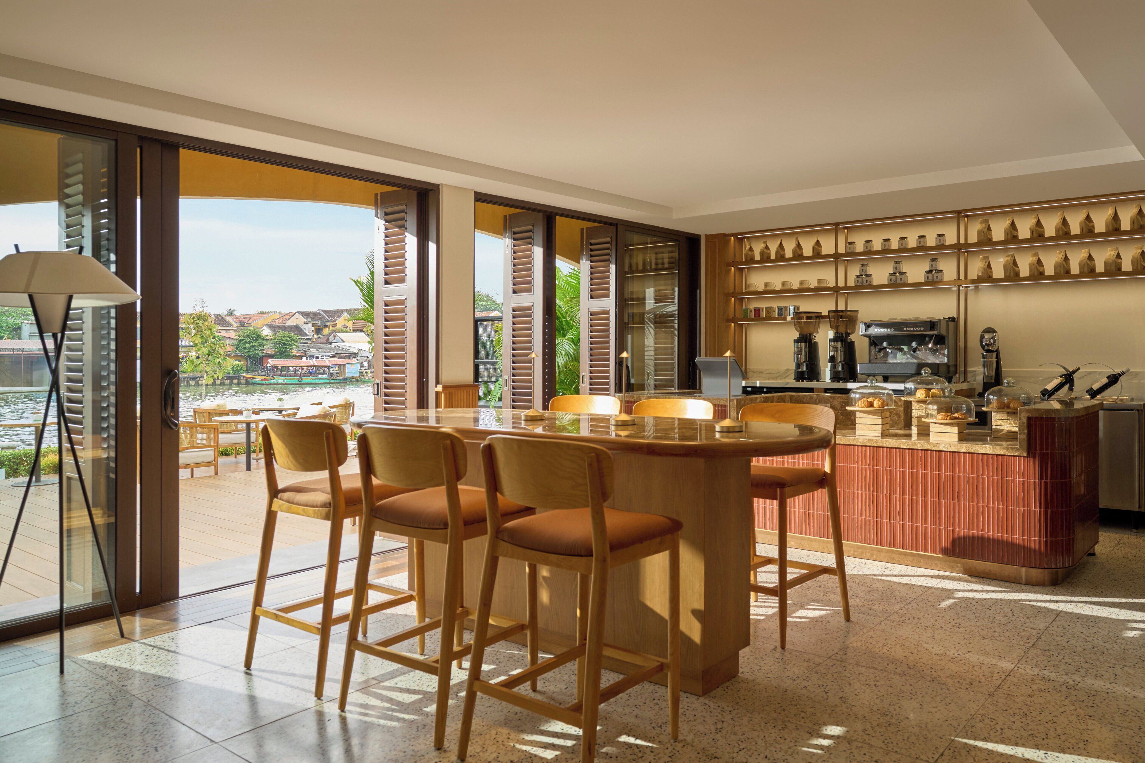 A modern kitchen with a bar area, large windows, and a view of the city.