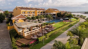 Un resort con piscina, mobiliario exterior y zona de bar.
