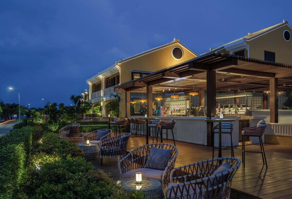 An outdoor bar area with wicker furniture and a bar counter.