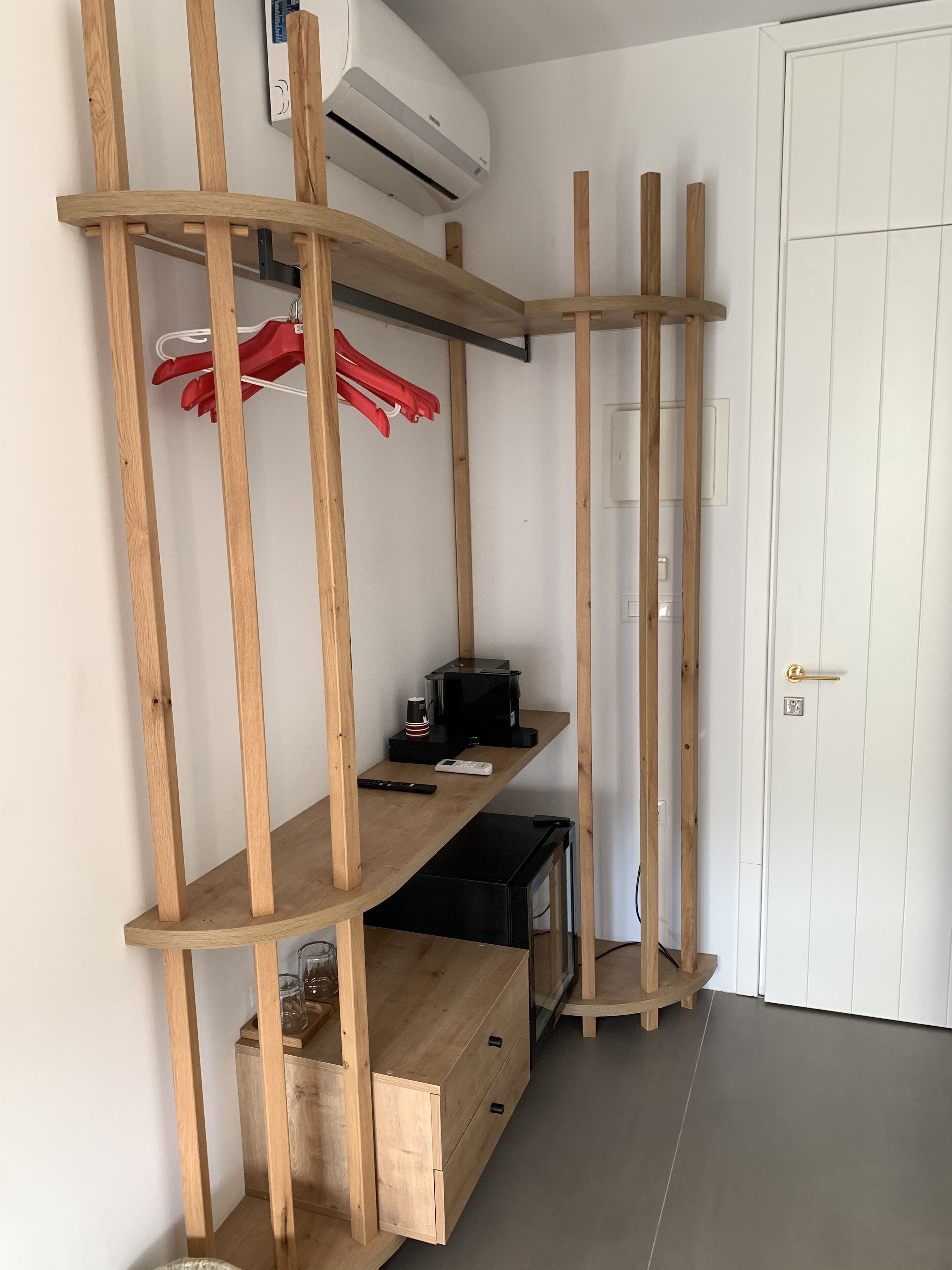 Une pièce avec une étagère en bois, un four à micro-ondes et une porte.