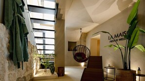 A modern indoor pool area with a hanging chair, a staircase, and a sign reading 'LA MAISON PRIVATE WELLNESS.' - La Maison Ostuni (chromotherapy and balcony) (Ostuni)