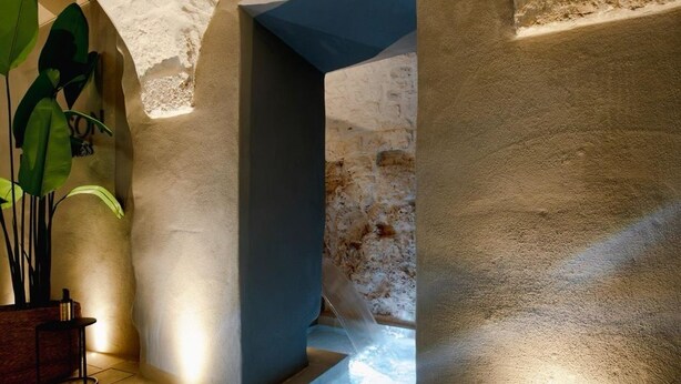 A spa area with stone walls, a water feature, and a seating area with a plant. - La Maison Ostuni (chromotherapy and balcony) (Ostuni)