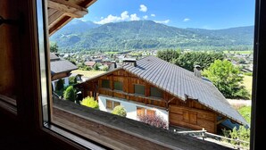 Una cabaña de madera con vistas a una montaña y un pueblo.