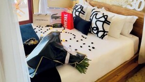A bedroom with a canopy bed, a bedside table with a lamp, a window with curtains, and a 'Happy 30th Birthday' sign.