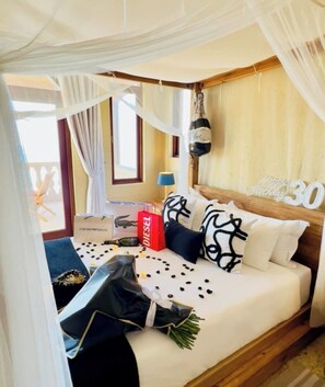 A bedroom with a canopy bed, a bedside table with a lamp, a window with curtains, and a 'Happy 30th Birthday' sign. - Bellavista! spectacular oceanviews (Dolphin Coast)