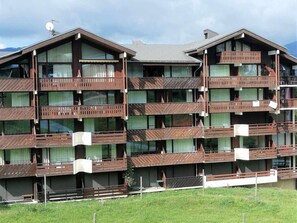 A multi-story hotel with balconies, large windows, and a flat roof.