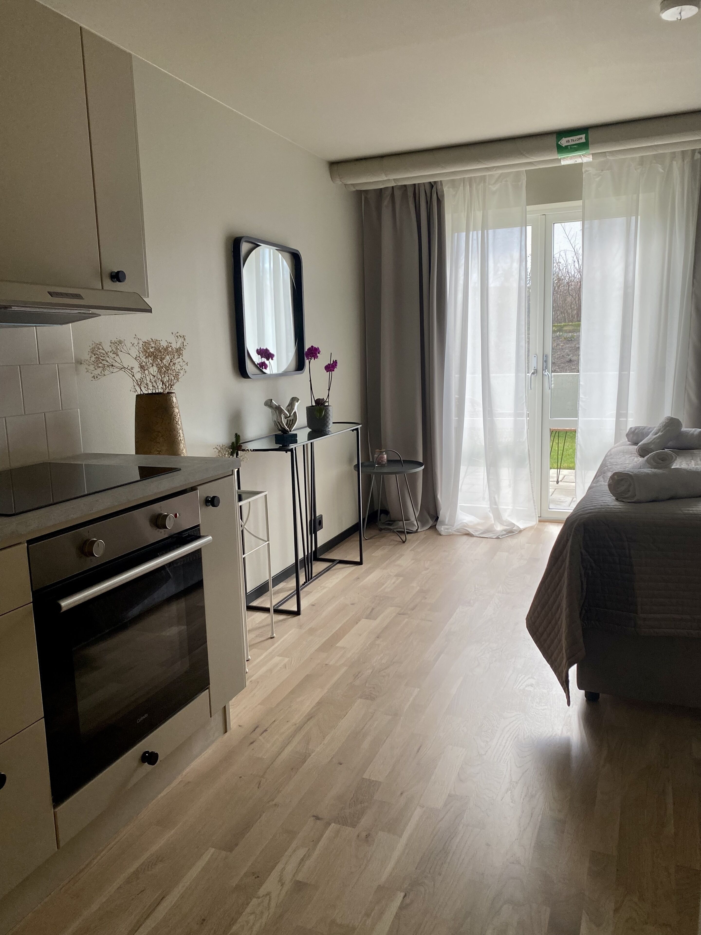 A modern kitchen with a built-in oven and a dining area with a table and chairs.