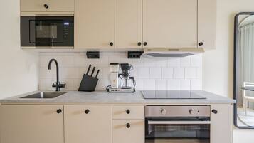 A modern kitchen with a built-in microwave, coffee maker, and oven.