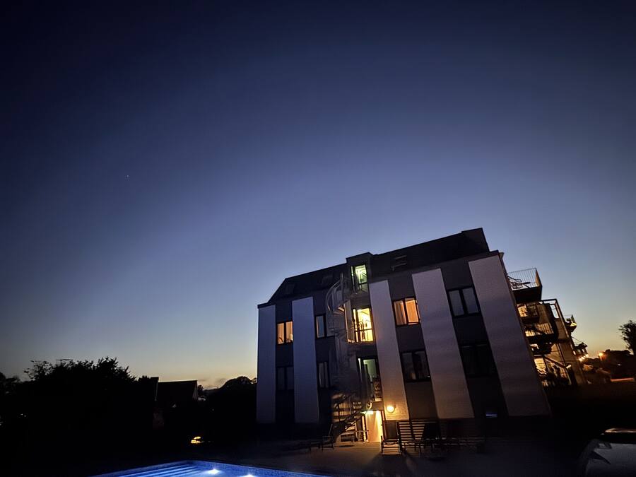 Ein modernes Gebäude mit Schwimmbad im Abenddämmerung.