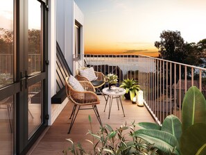 A balcony with wicker chairs, a small round table, and potted plants. - Hotell Hanöhus Hällevik (Sölvesborg)