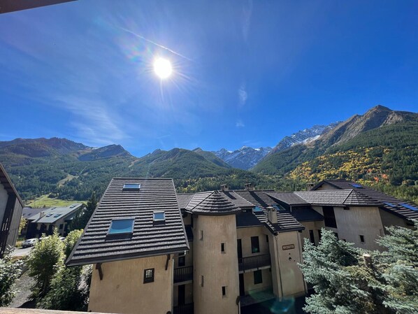 A building with multiple roofs, a clear sky, and mountains in the background.