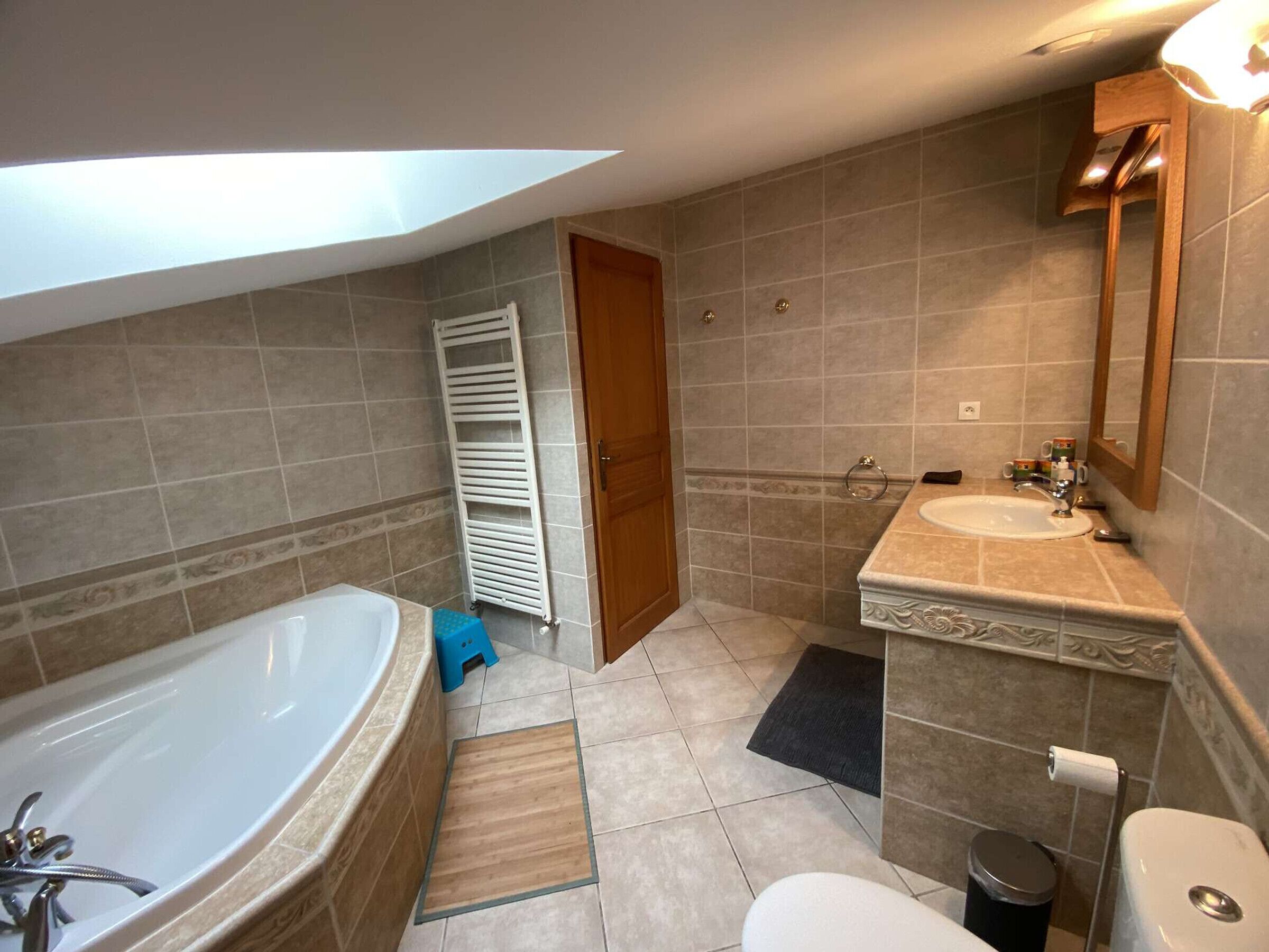 A modern bathroom with a bathtub, a sink, and a toilet.