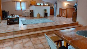 Ein geräumiges Loft mit Küche, Essbereich und einer Treppe zu einer oberen Ebene.