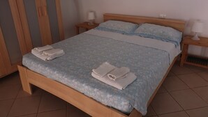 Een bed met een bloemenprint dekbed, twee kussens en twee nachtkastjes met lampen.