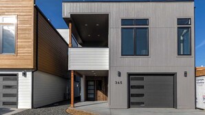 A modern two-story house with a garage, a balcony, and a driveway. - New 3 story home - Walking distance to the Milwaukee Trail and Good Food Store (Missoula)