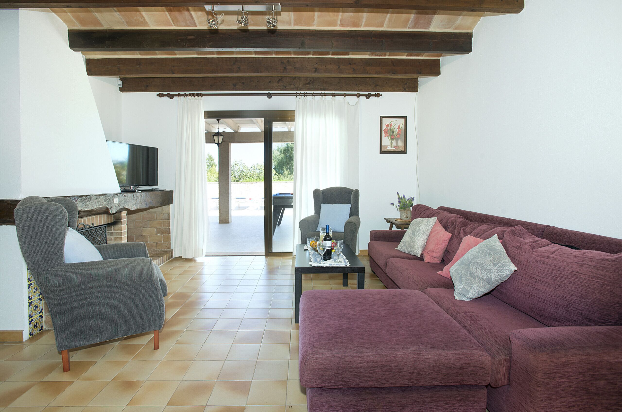 A living room with a TV, a fireplace, a sofa, and a chair.
