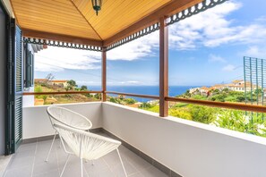 A balcony with a view of the sea and buildings. - Villa Dinis (Calheta)