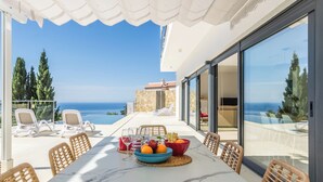 A terrace with a table set for dining, overlooking the sea. - Villa La Perla with private heated pool and great views (Salobreña)